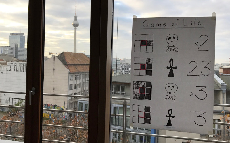 a poster of the rules of game of life, put up on a window in Berlin
